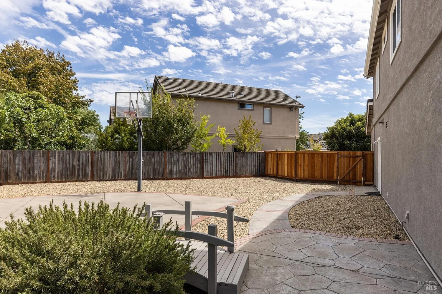 Backyard hardscape with basketball half-court and privacy fencing