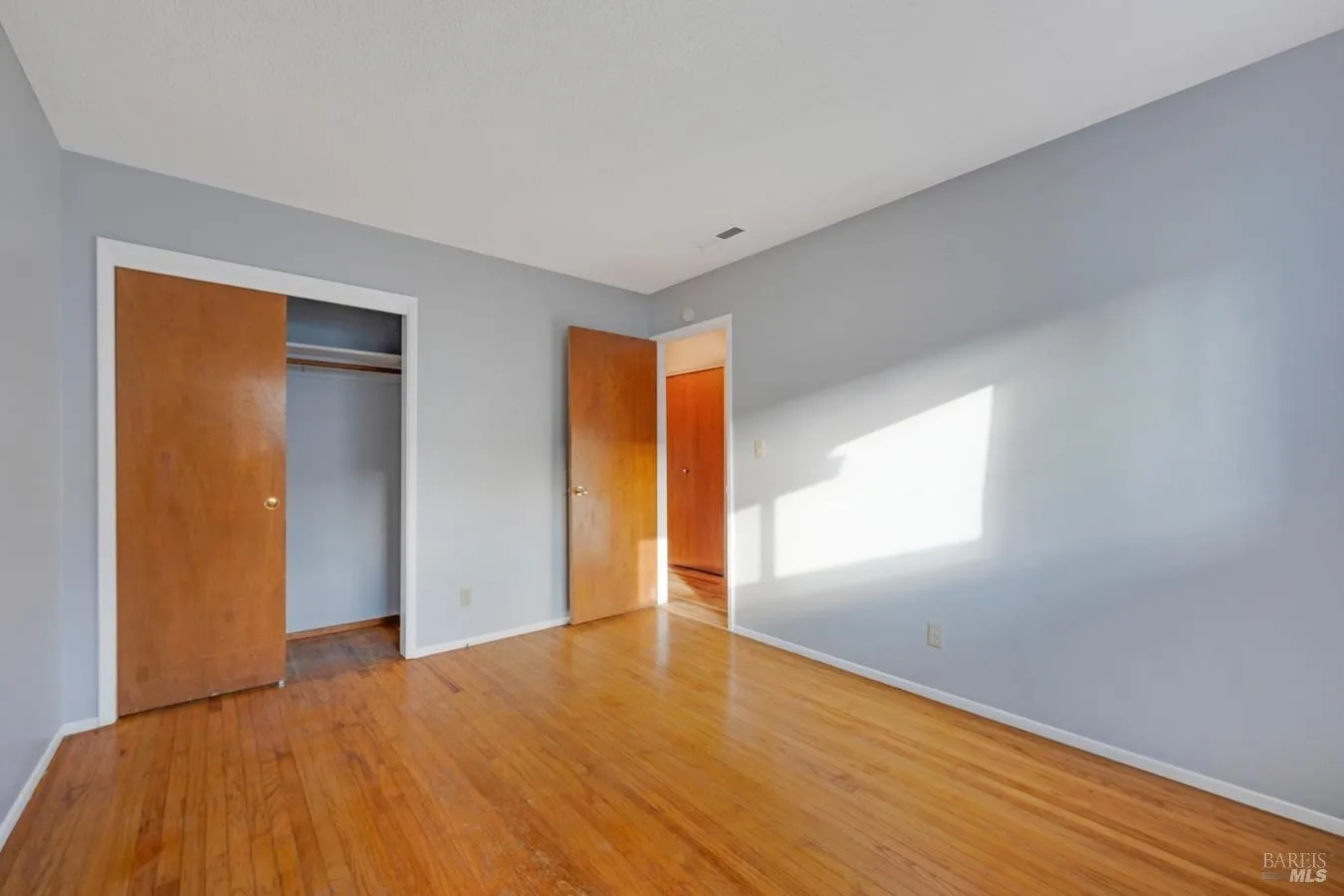 Bedroom with hardwood floors and closet