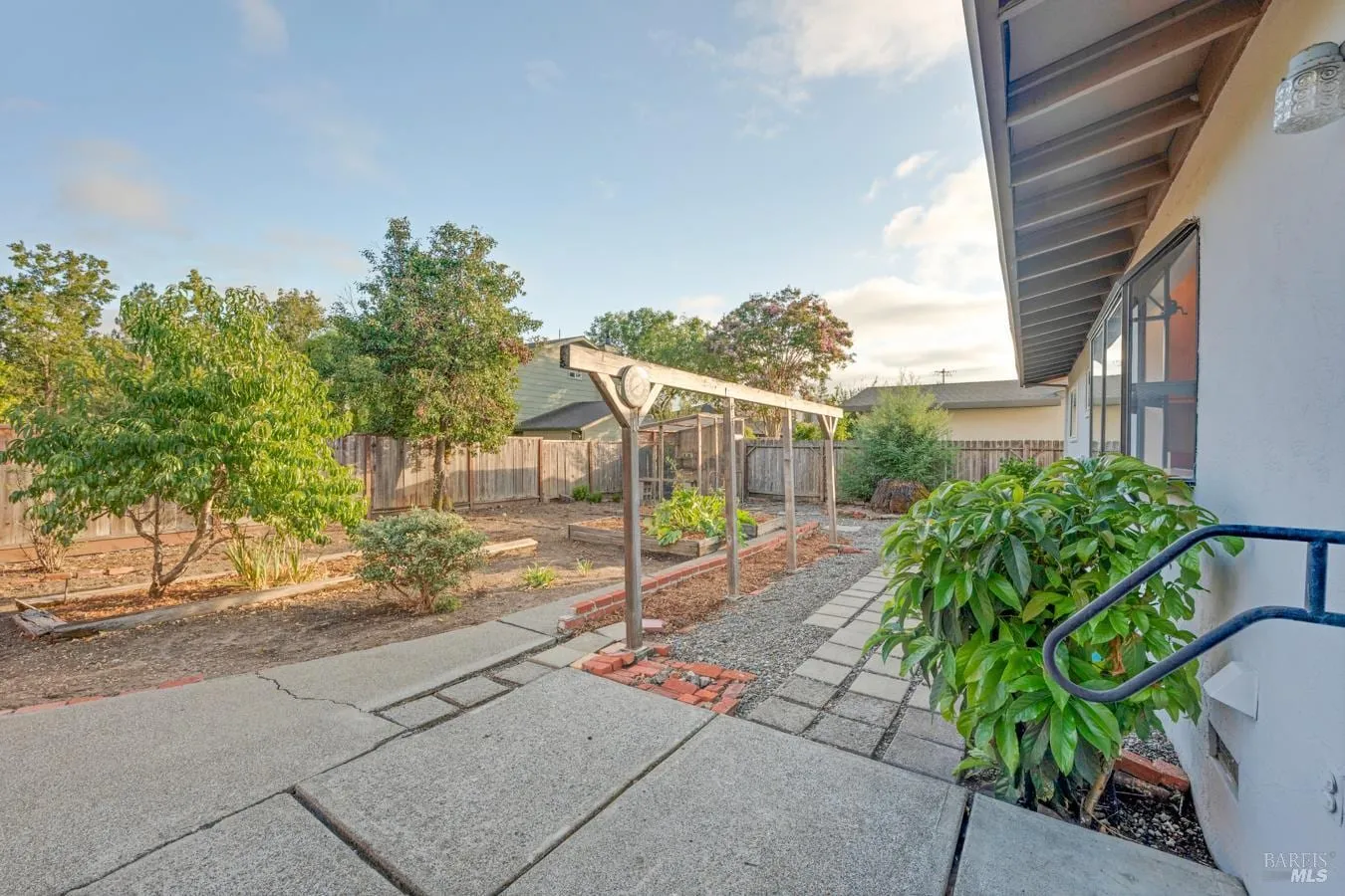 Side yard patio, gravel paths, and raised planters