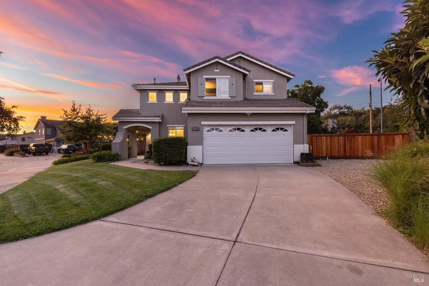 Sunset curb appeal of 4122 Cedar Creek Court with glowing windows and manicured lawn