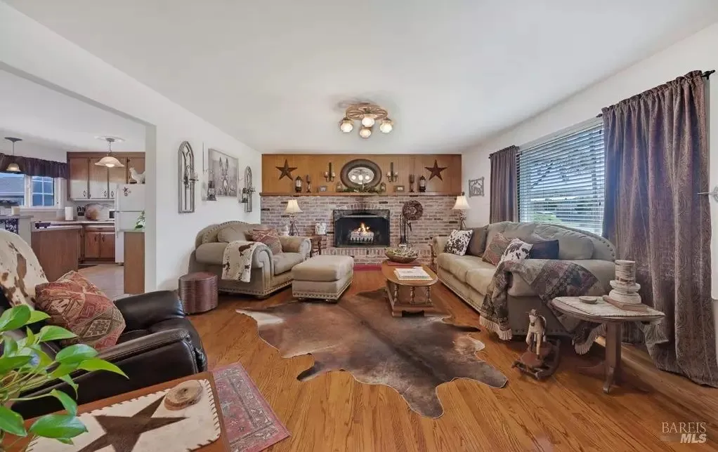 Living room with brick fireplace and hardwood floors